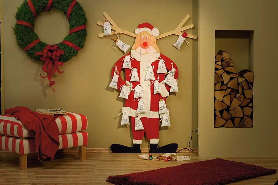 Ein weihnachtlich geschmückter Raum mit einem Adventskalender in Form eines Weihnachtsmannes.